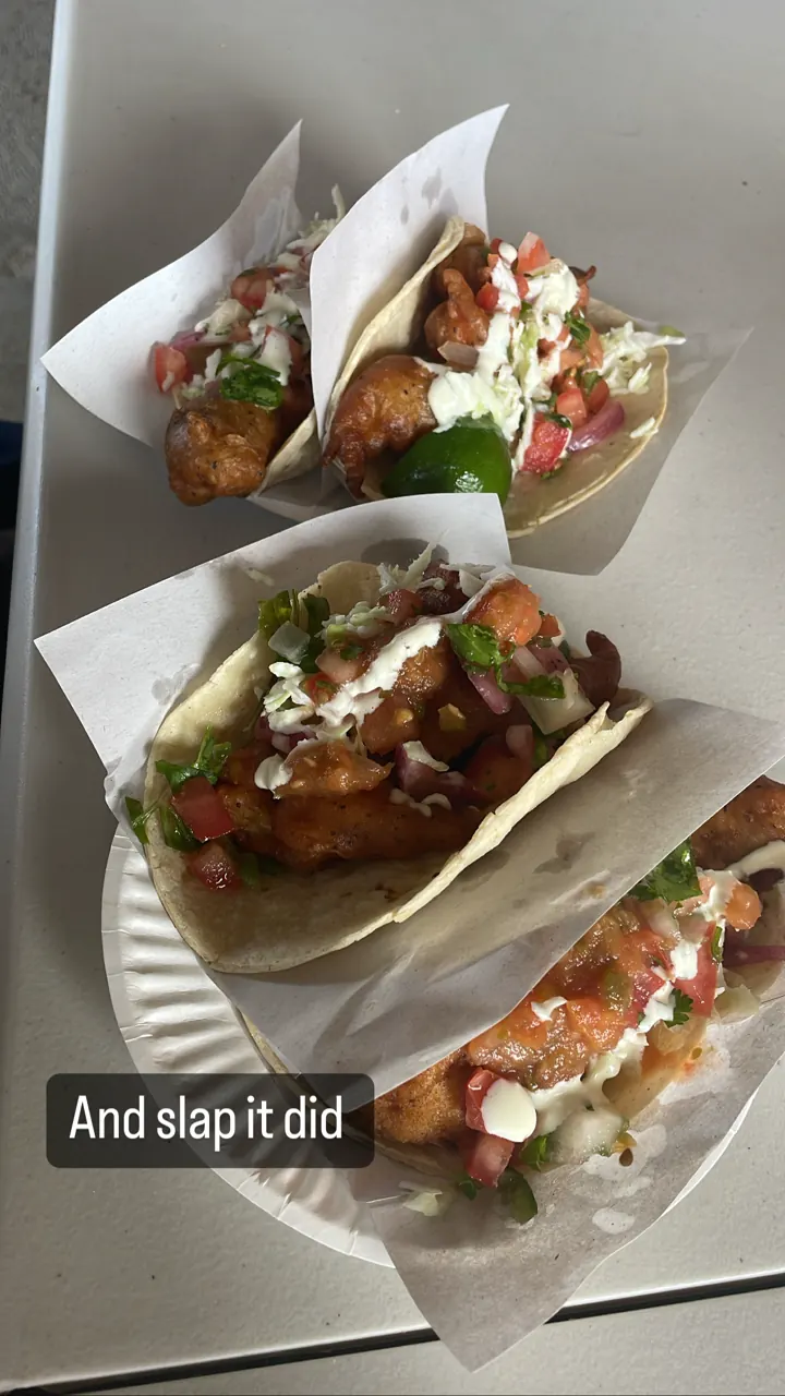 Plate of battered fish tacos topped with slaw and sauce