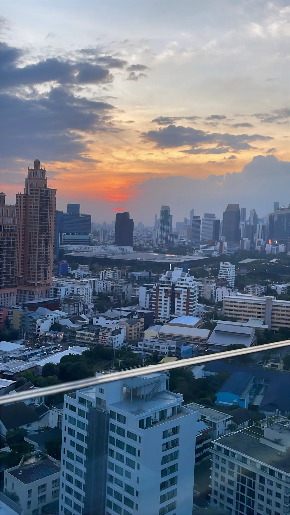 Bangkok skyline of high-rise towers under a pink and blue sunset sky