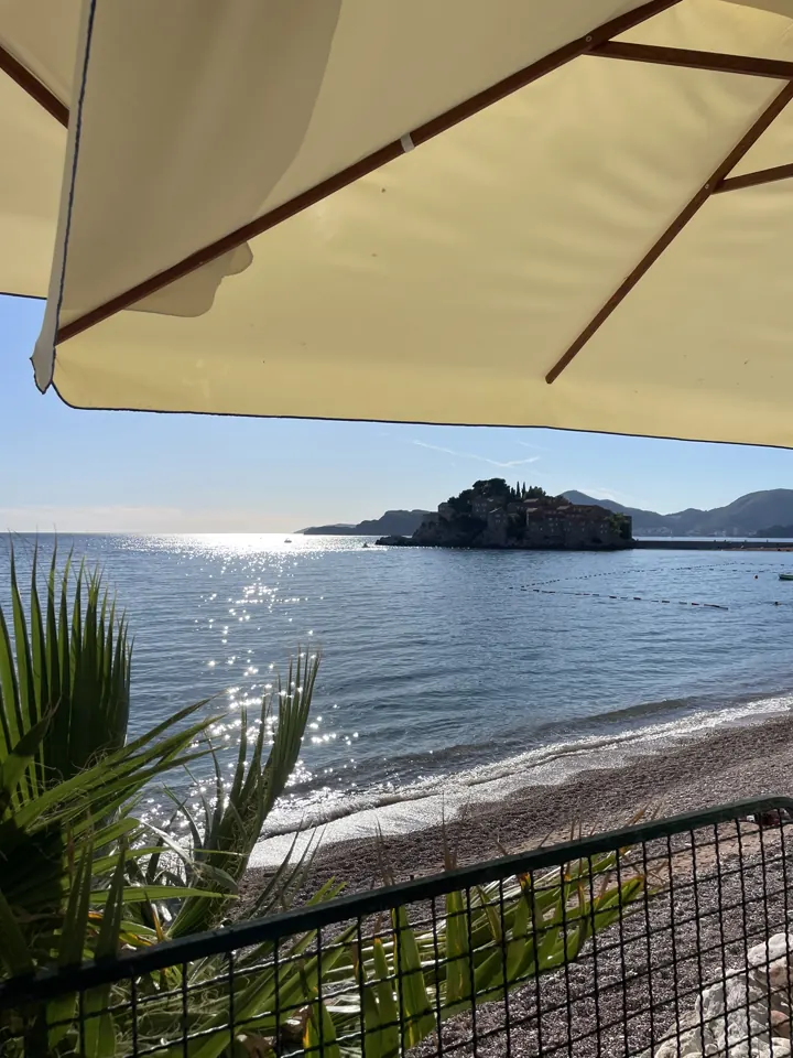 The island of Sveti Stefan seen from under a beach umbrella