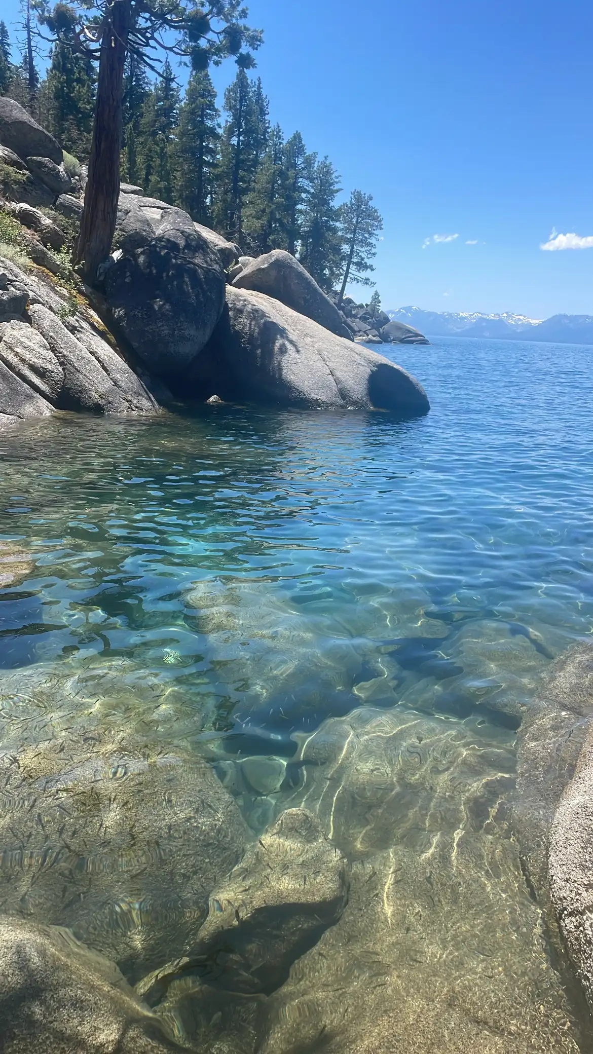 Crystal-clear turquoise water over granite boulders on the Lake Tahoe shoreline