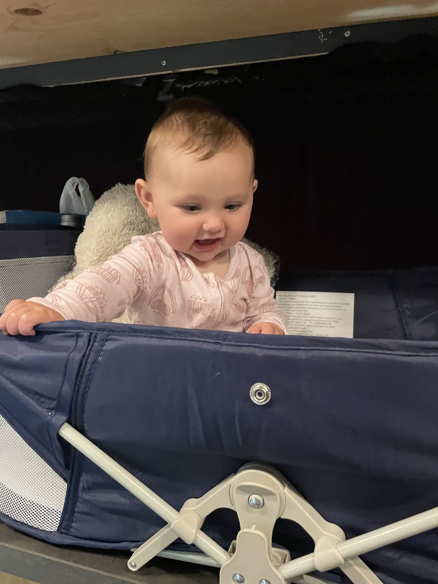 Andi smiling in her travel crib in the van