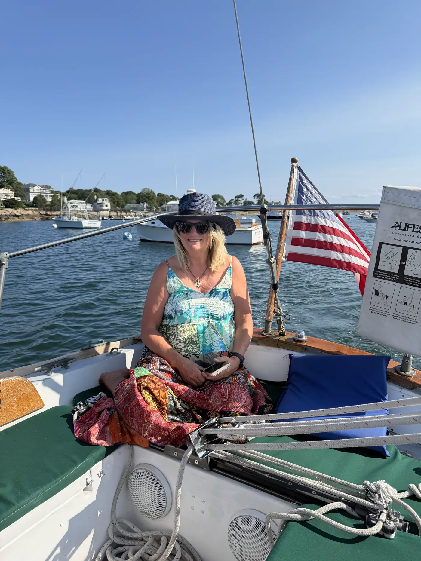 A sailboat with an American flag on the water off Marblehead