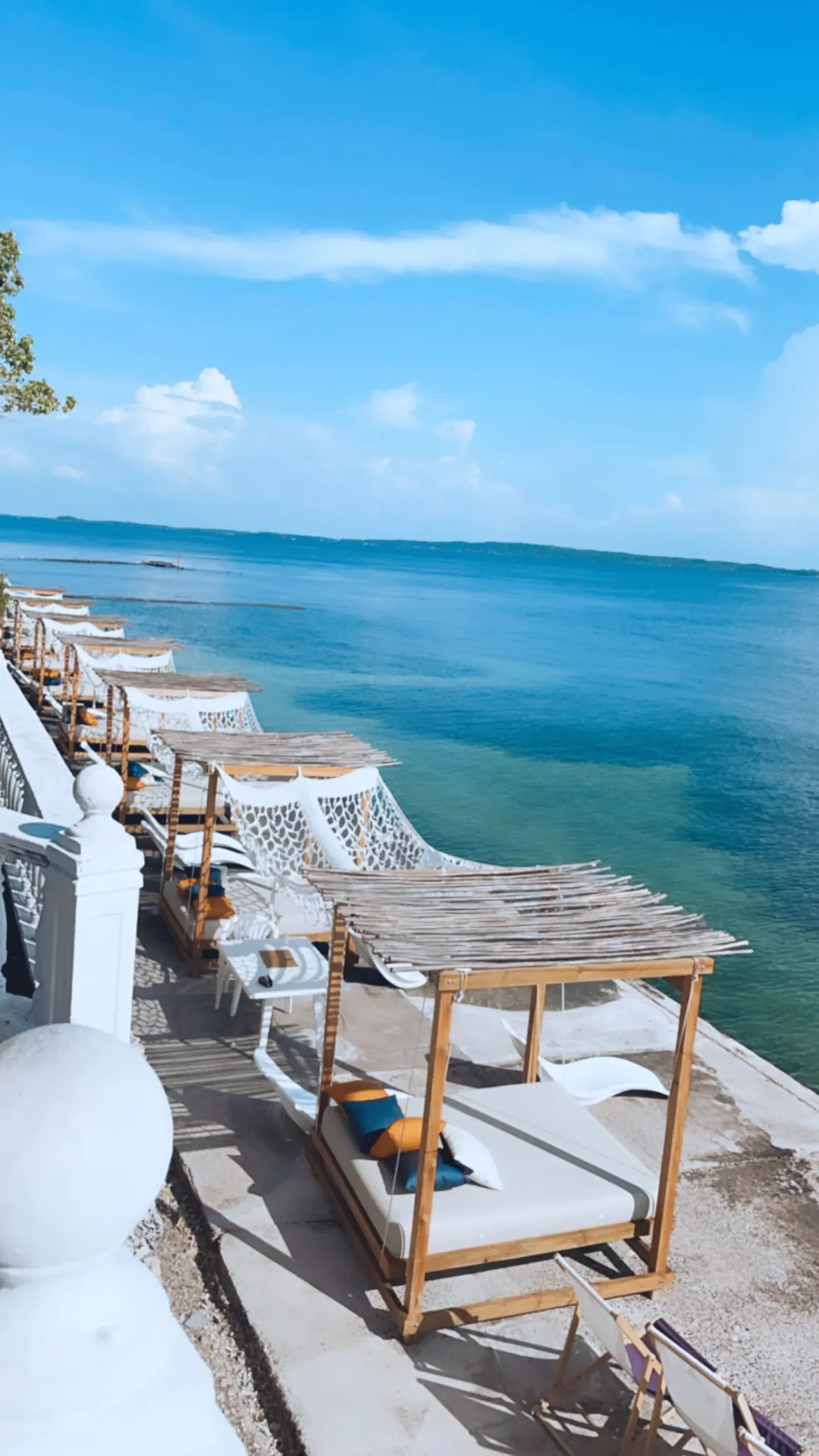 Lounge chairs on a deck overlooking turquoise Caribbean water