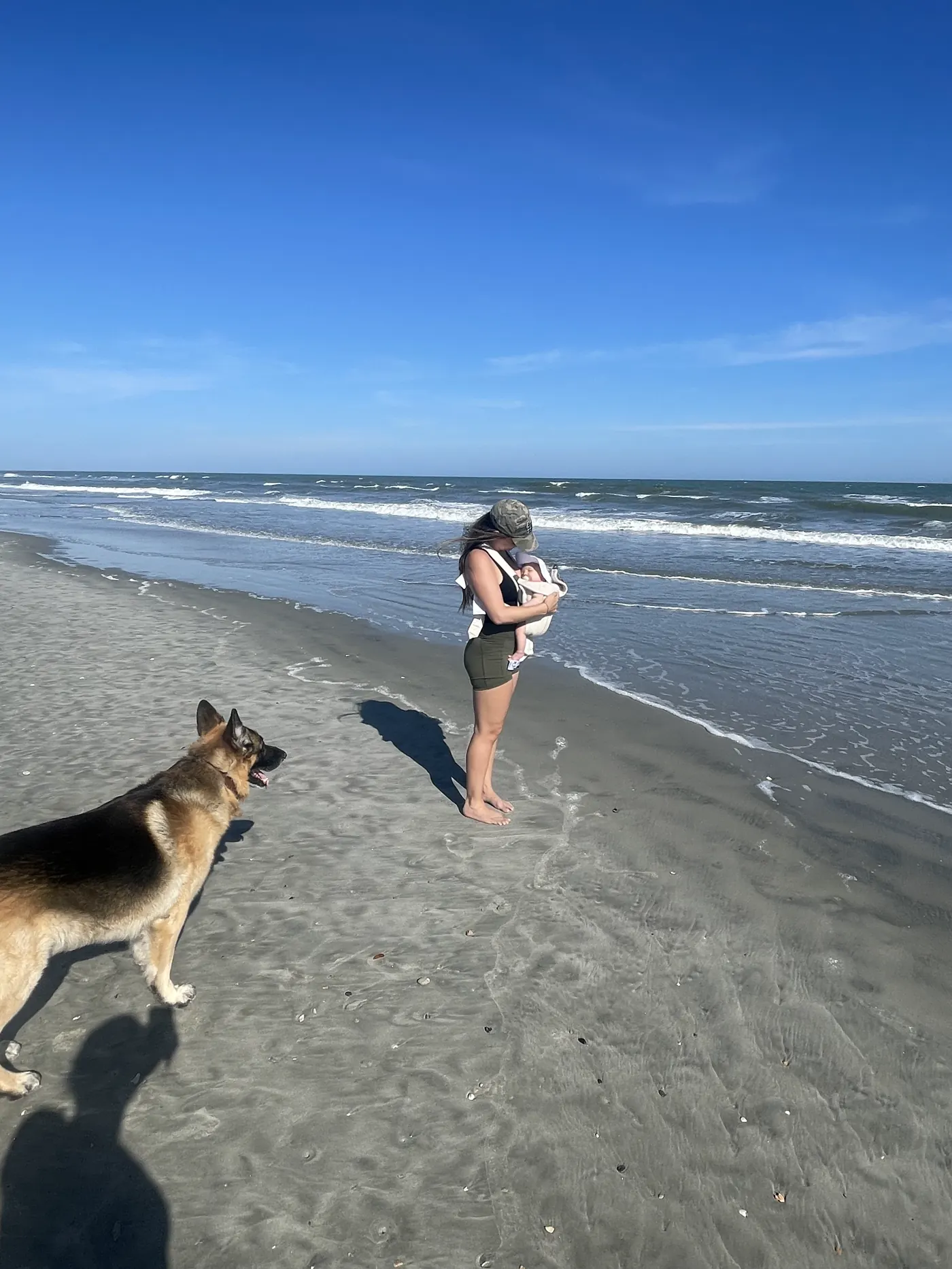 Angela carrying Andi on Folly Beach with our German Shepherd