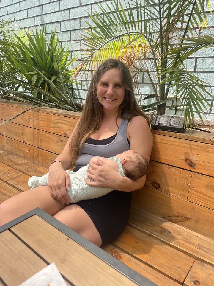 Angela holding Andi on a porch surrounded by plants