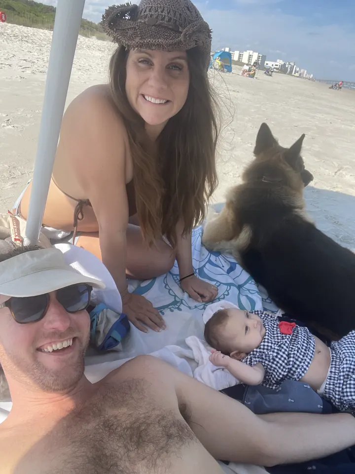 Colin, Andi and our German Shepherd on a beach blanket
