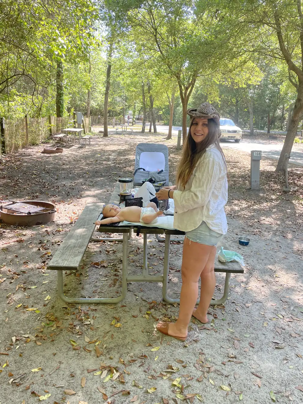 Angela at a picnic table at a wooded campsite at Myrtle Beach State Park