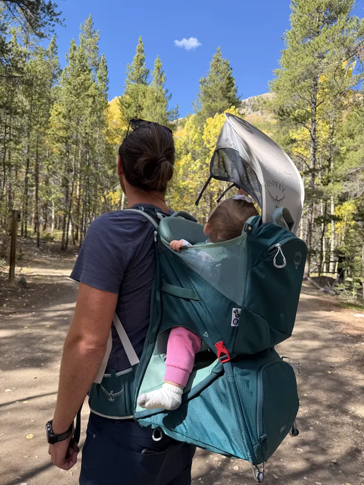 Colin carrying Andi in the hiking carrier on a trail
