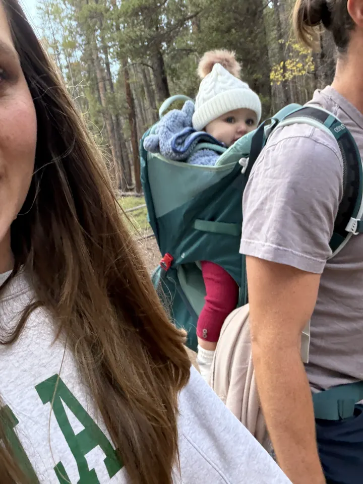 Andi riding in the hiking carrier on a forest trail
