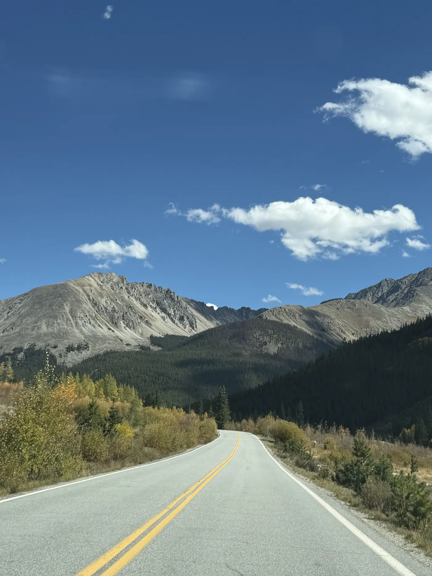 A two-lane mountain road near Twin Lakes with peaks ahead