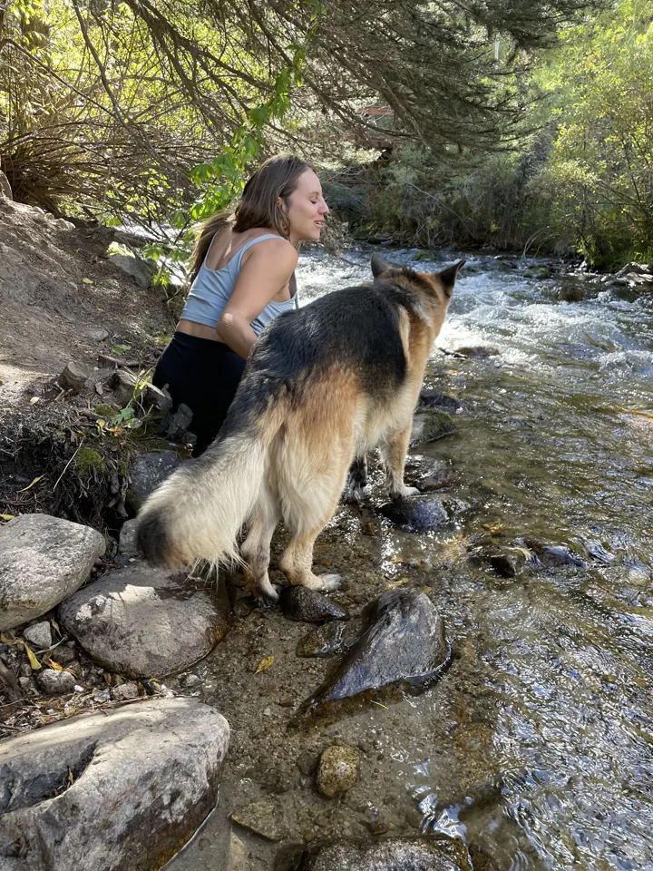 Angela with Jack, our German Shepherd, standing in a rocky creek