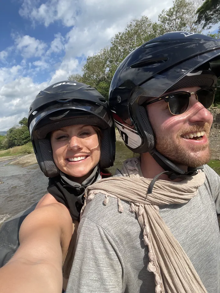A man and woman in helmets taking a selfie outdoors