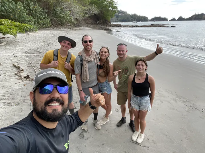 A group of friends taking a selfie on a sandy beach