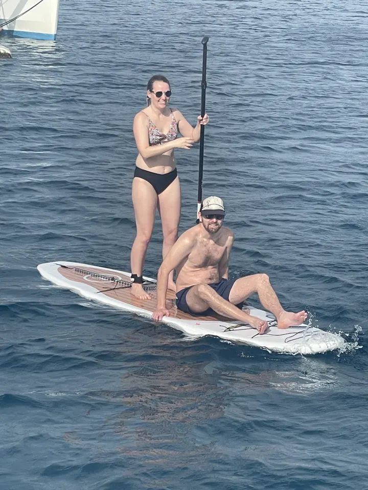 Two people on a paddleboard on open blue water