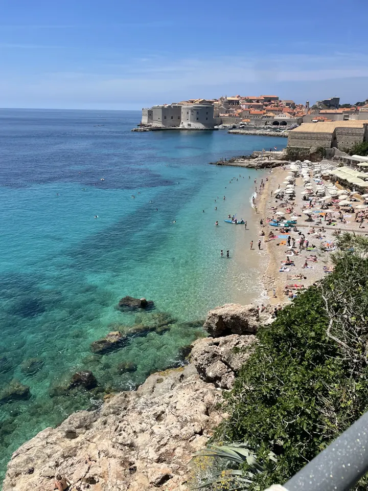 Turquoise water and a beach below Dubrovnik's Old Town walls