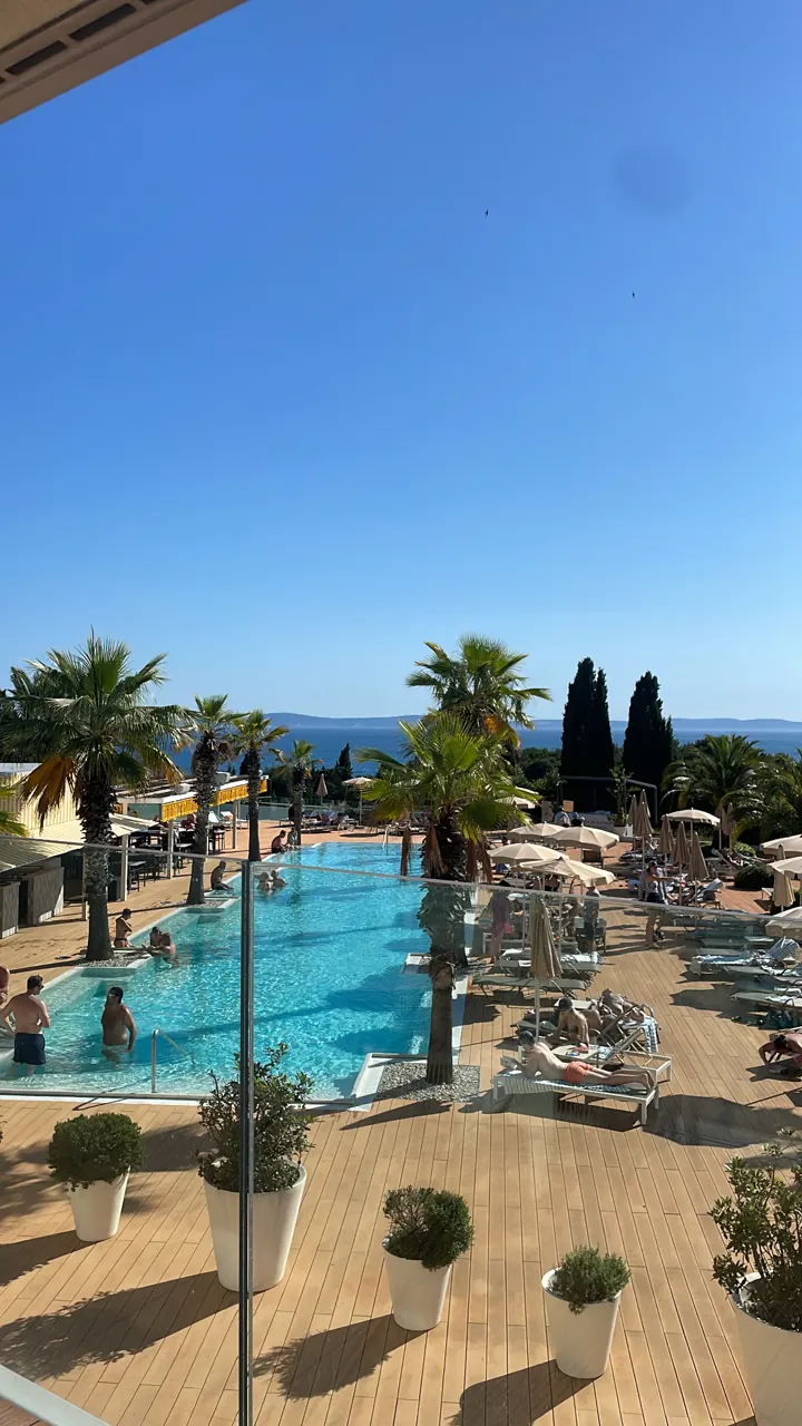 A resort pool with palm trees in Split