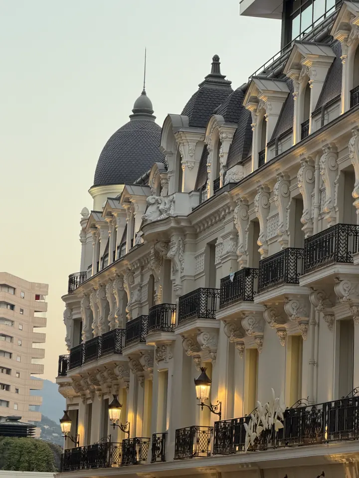 Ornate belle-époque building with domes and balconies at dusk in Monaco