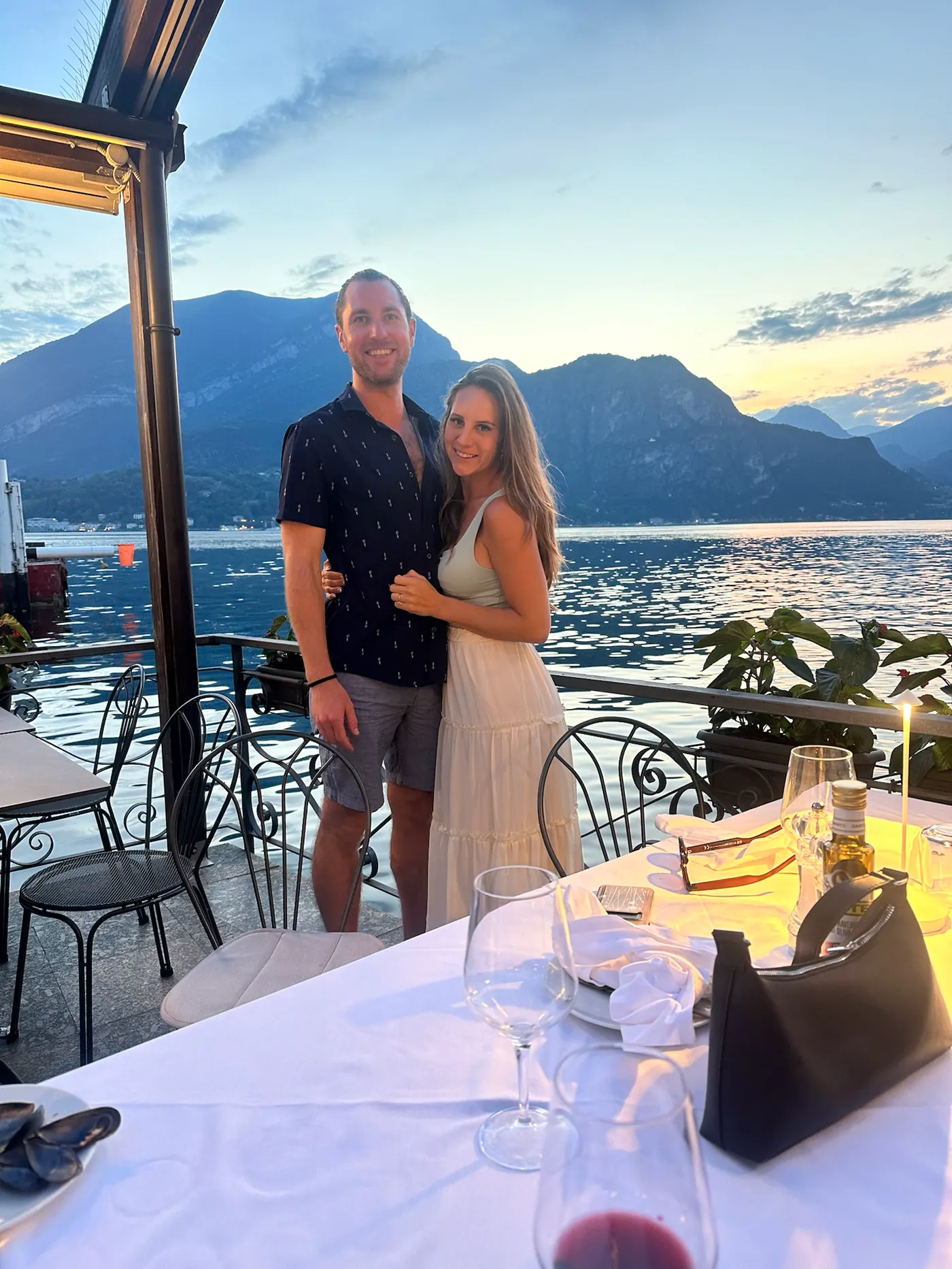 Colin and Angela on a lakeside terrace with mountains behind