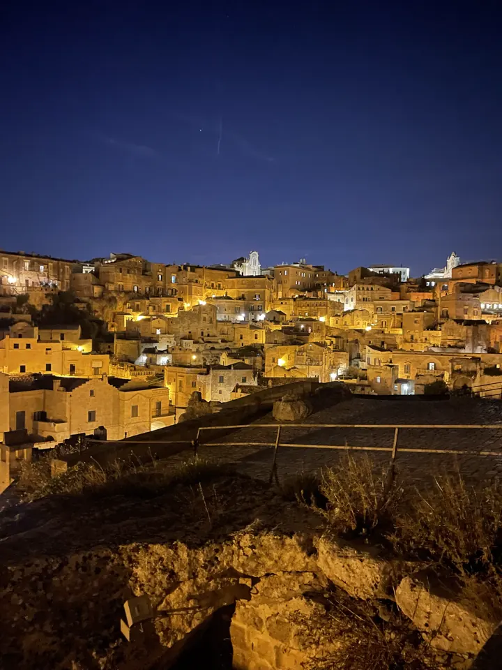 Matera's stone city glowing with lights at night