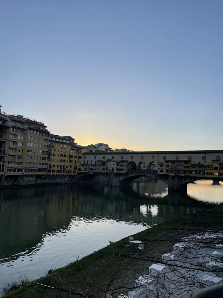 Ponte Vecchio and riverside buildings reflected in the Arno at dusk