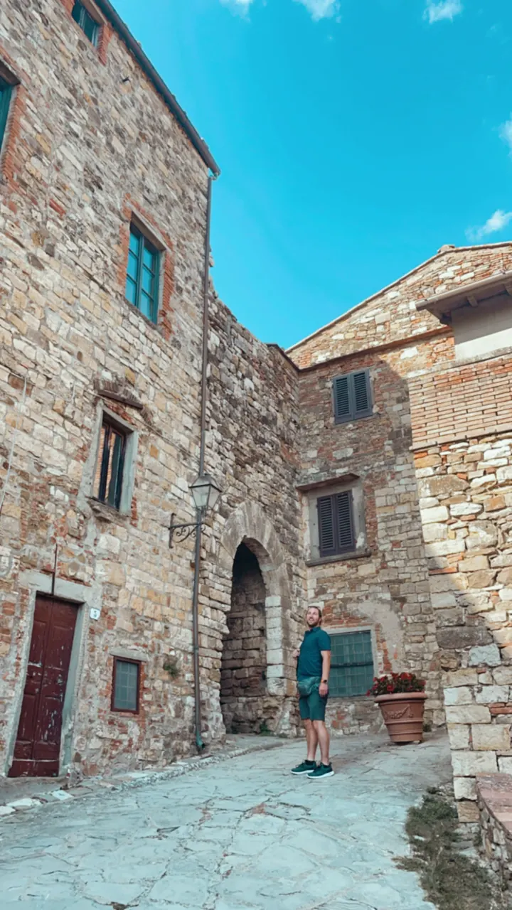 A stone lane with an arch and old buildings in a hill town