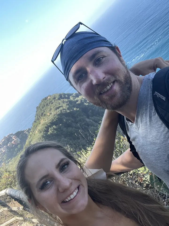 A couple taking a selfie on a hiking trail high above the sea