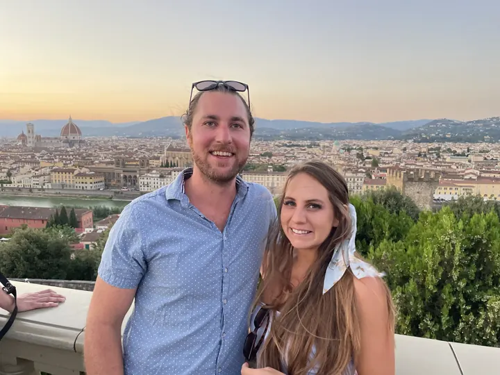 A couple posing at a hilltop overlook above the Florence rooftops