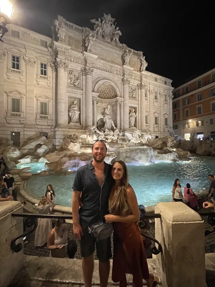 A couple at the illuminated Trevi Fountain at night