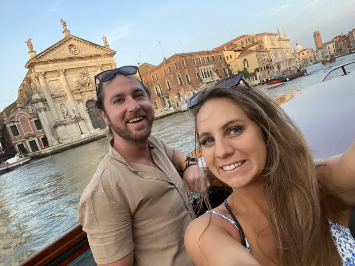 A couple taking a selfie on a boat on the Grand Canal in early morning light