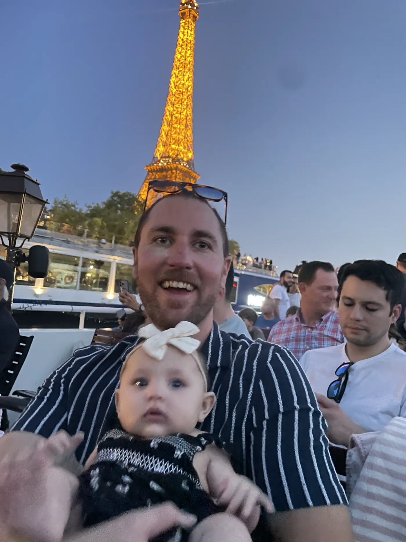 Colin holding Andi in front of the Eiffel Tower lit up at night