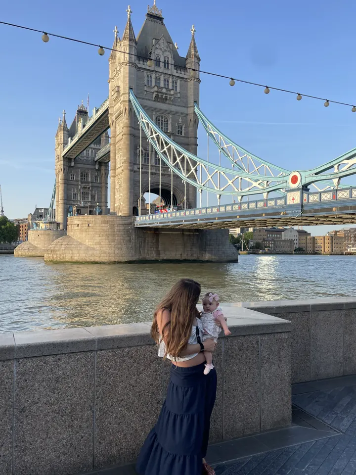 Angela holding Andi by the Thames with Tower Bridge behind