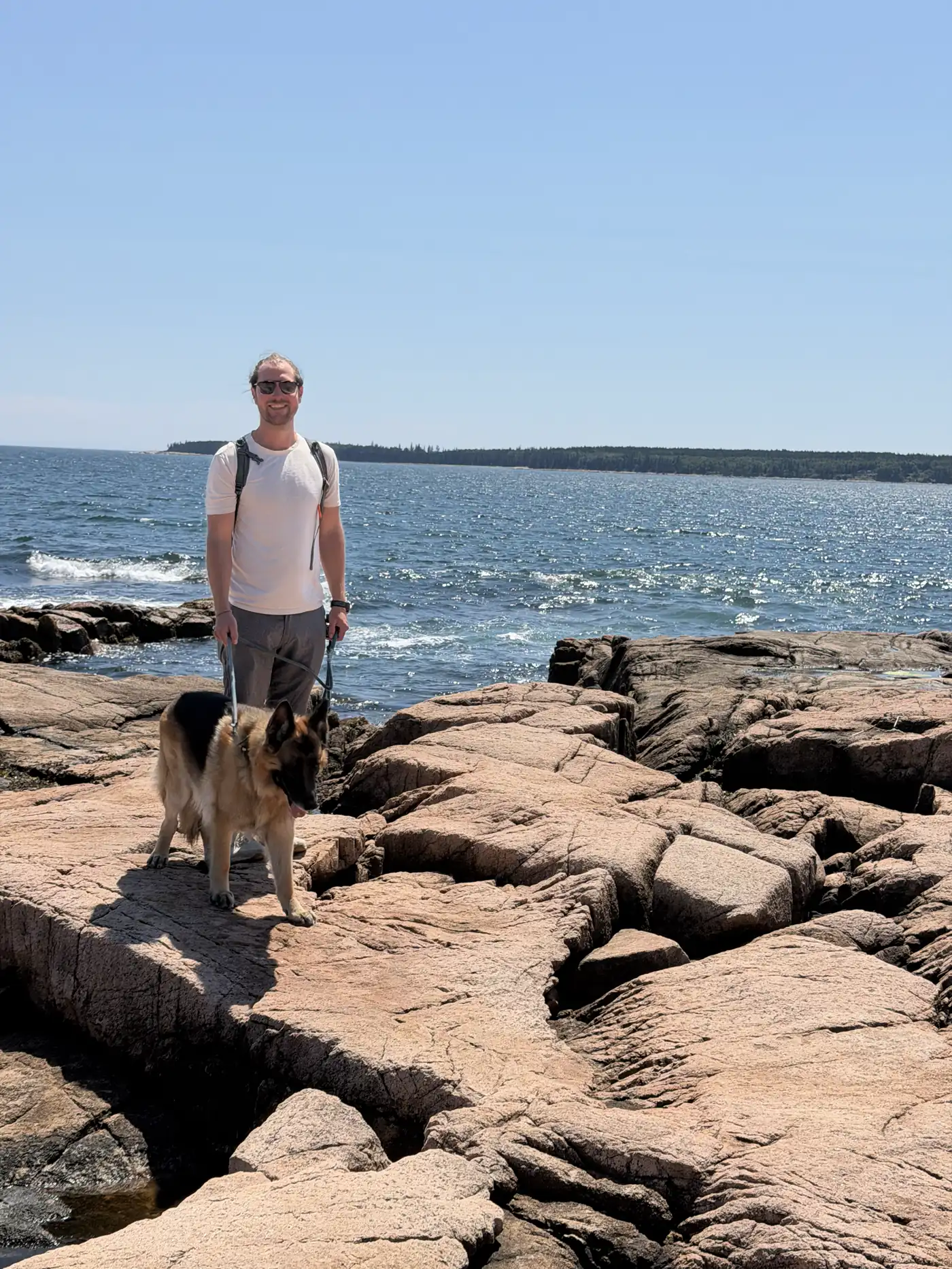 Colin and our German Shepherd standing on pink granite at Acadia National Park