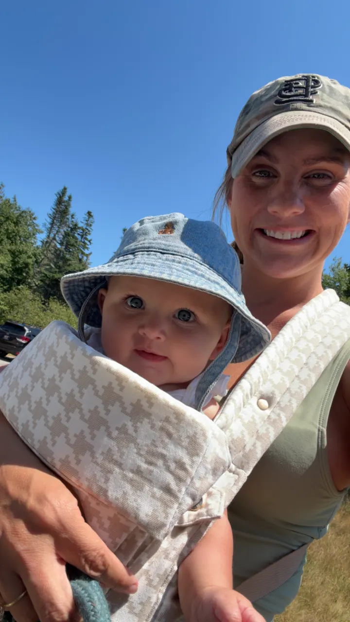 Angela holding Andi in a bucket hat with a park map