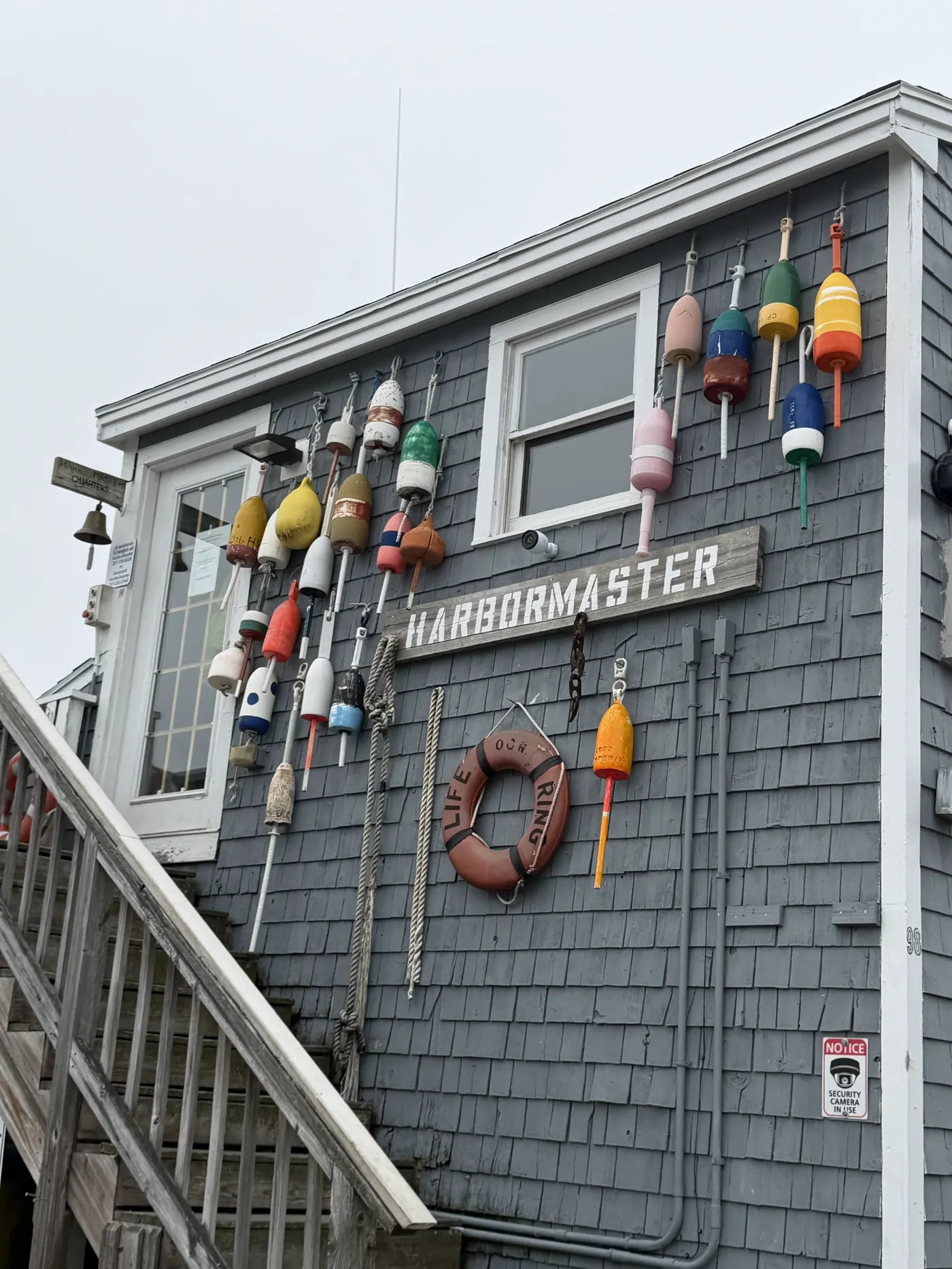 A gray shingled shack covered in colorful lobster buoys in Ogunquit