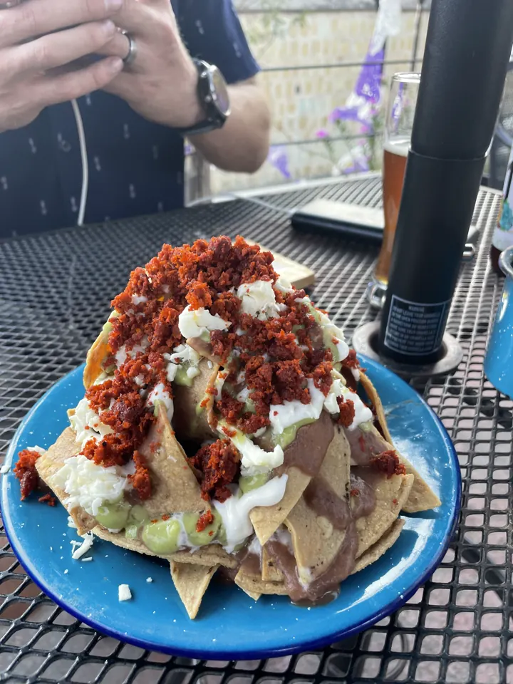 Heaping plate topped with red salsa, cream, and onions on a blue plate