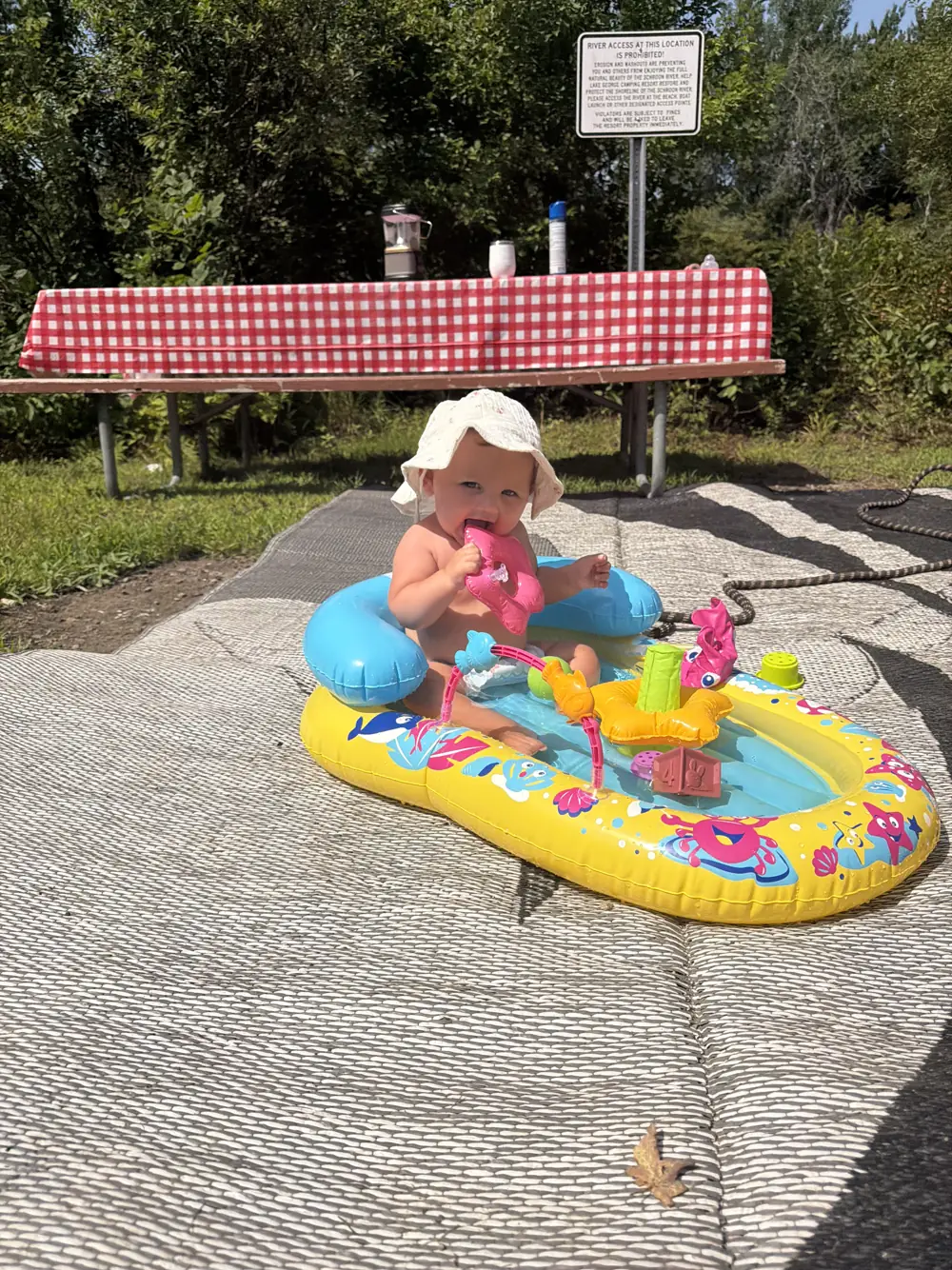 Andi in a colorful baby floatie under a picnic shelter