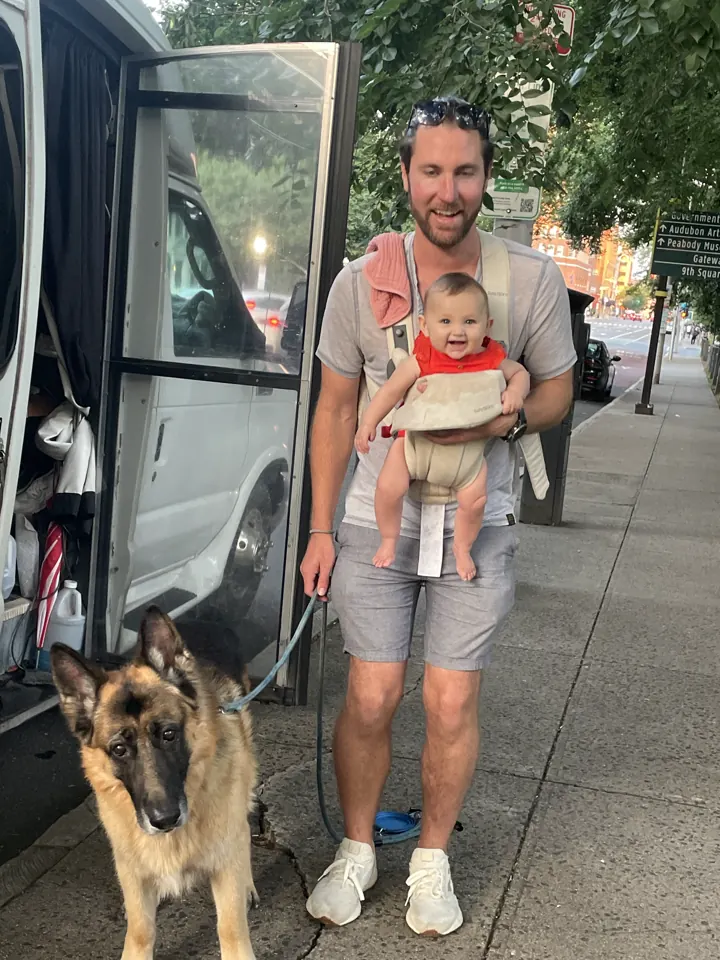 Colin with Andi in the carrier and Jack sitting by the van