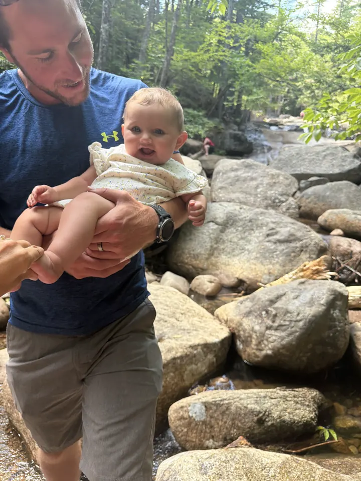 Colin holding Andi on the rocks by a mountain river