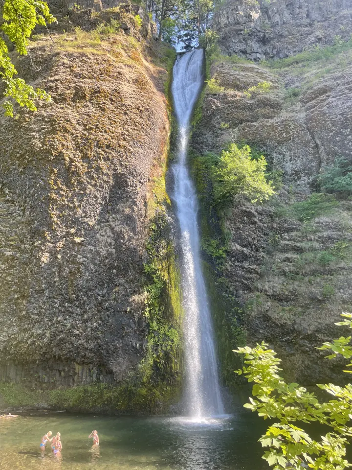 Thin waterfall dropping down a mossy cliff into a pool