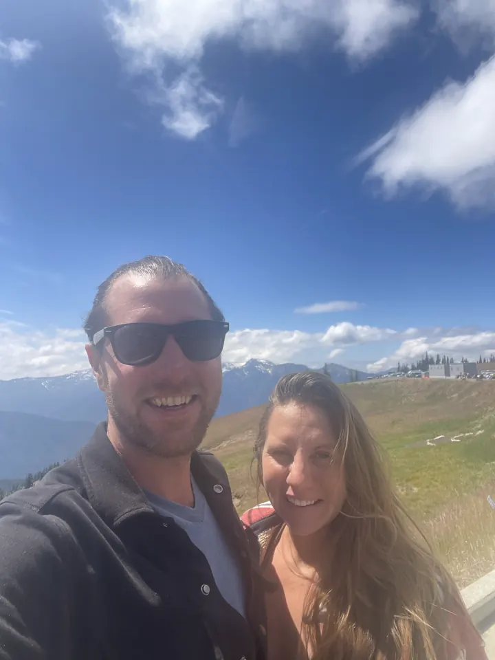 Colin and Angela selfie with mountains and meadow behind