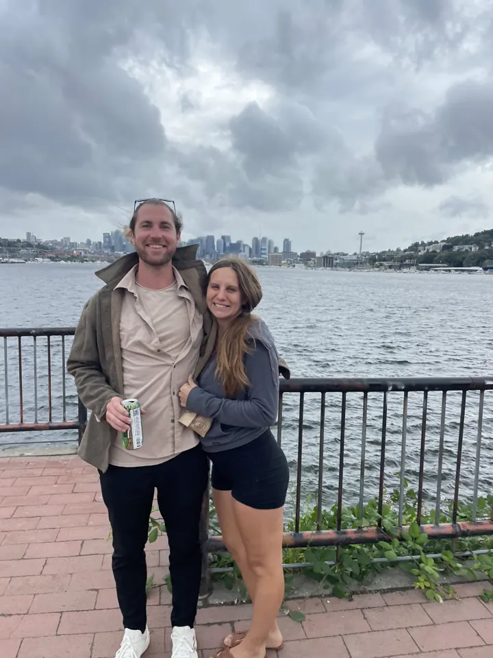 Colin and Angela standing at a railing with the Seattle skyline across the water