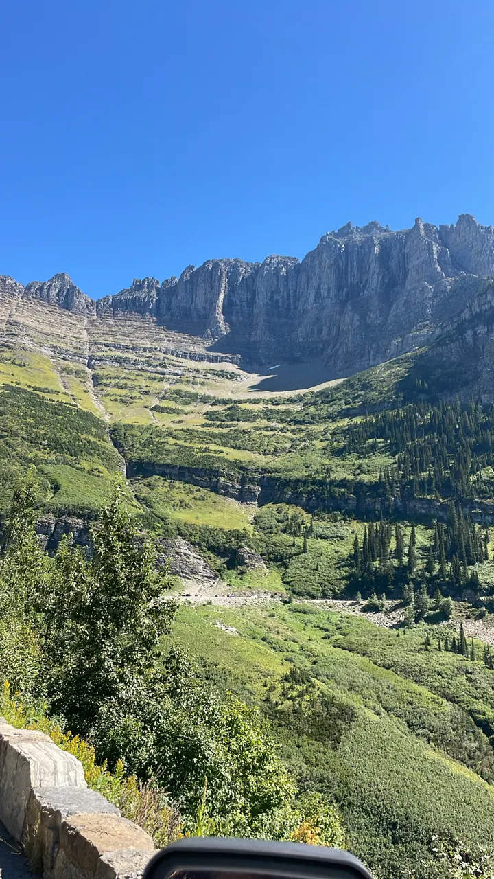 Green valley and layered cliffs along a mountain road