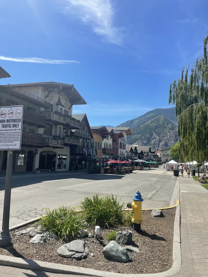 Bavarian-style buildings along a street in Leavenworth with mountains behind