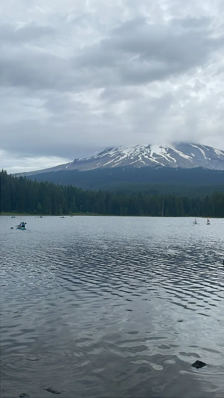 Snowy Mount Hood beyond a calm lake under clouds