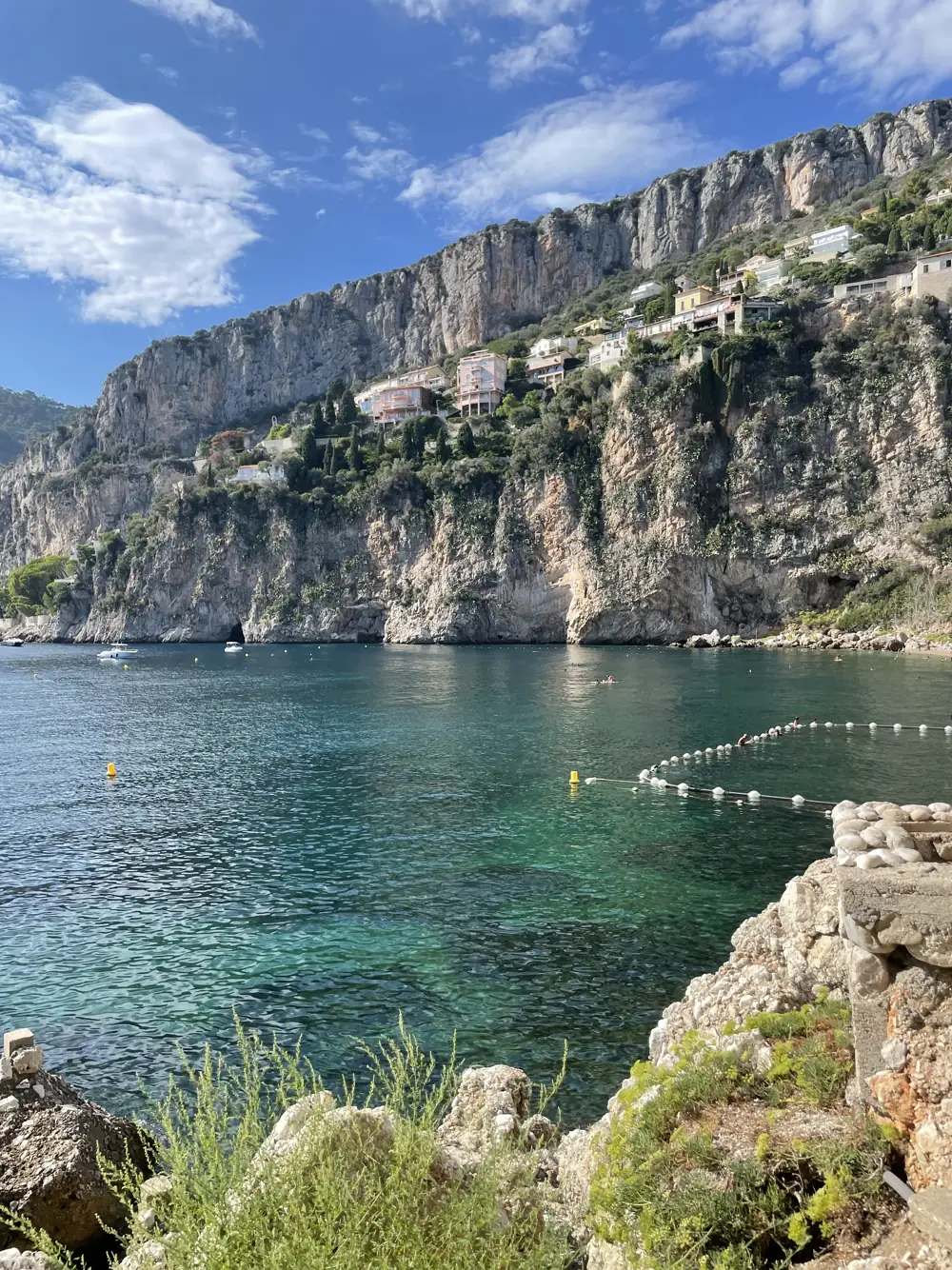 Clear turquoise water in a cove below limestone cliffs