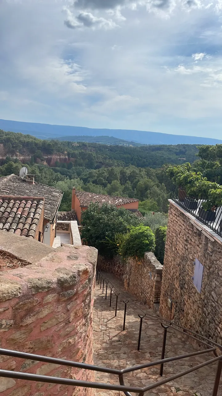Stone rooftops and green hills seen from a hilltop village