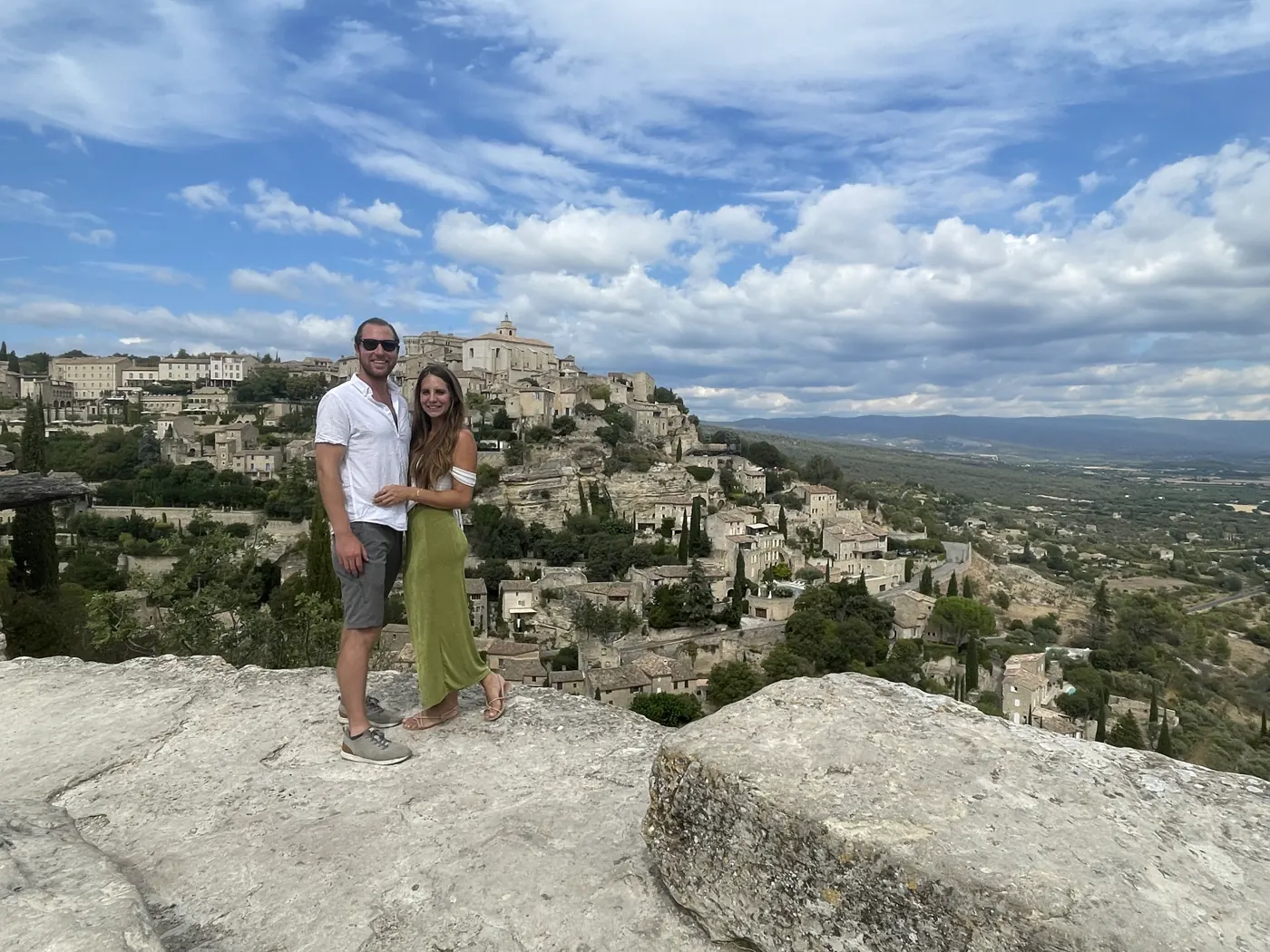 A couple on rocks overlooking a wide valley