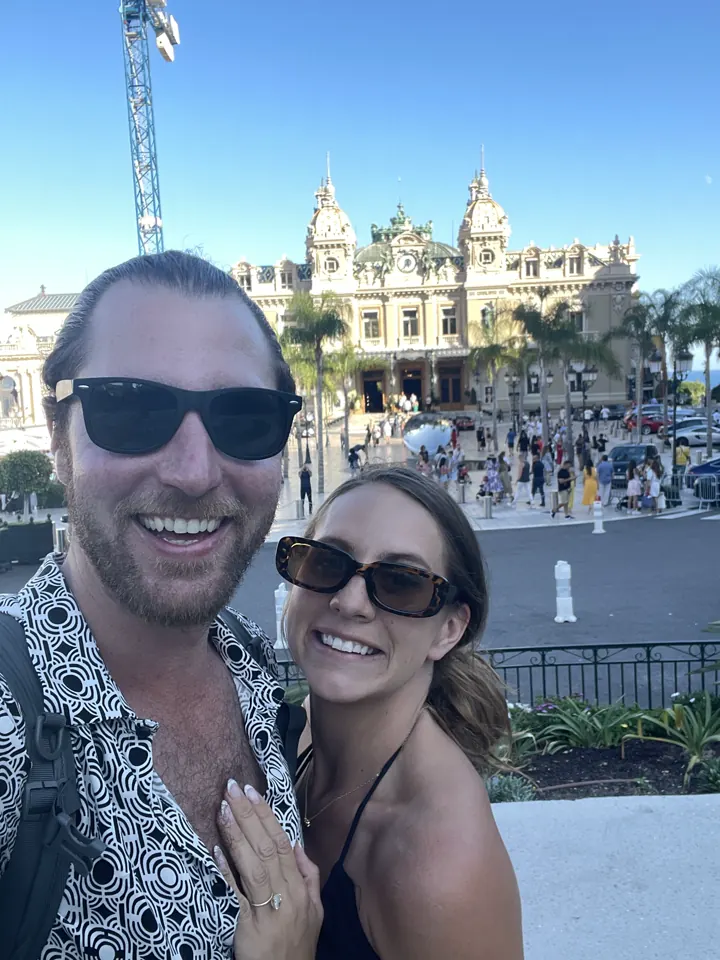 A couple taking a selfie in front of the Monte Carlo casino