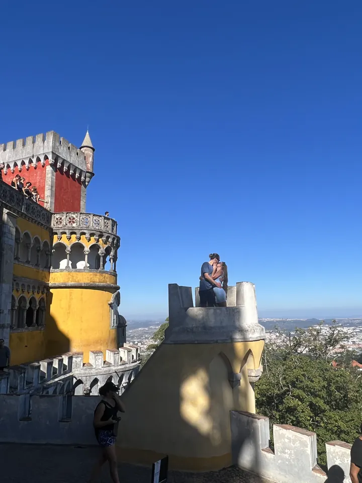 Red and yellow towers of Pena Palace against a blue sky