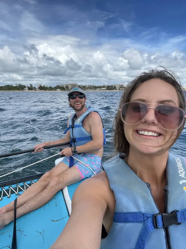 A man and a woman in life jackets take a selfie on a boat on the water